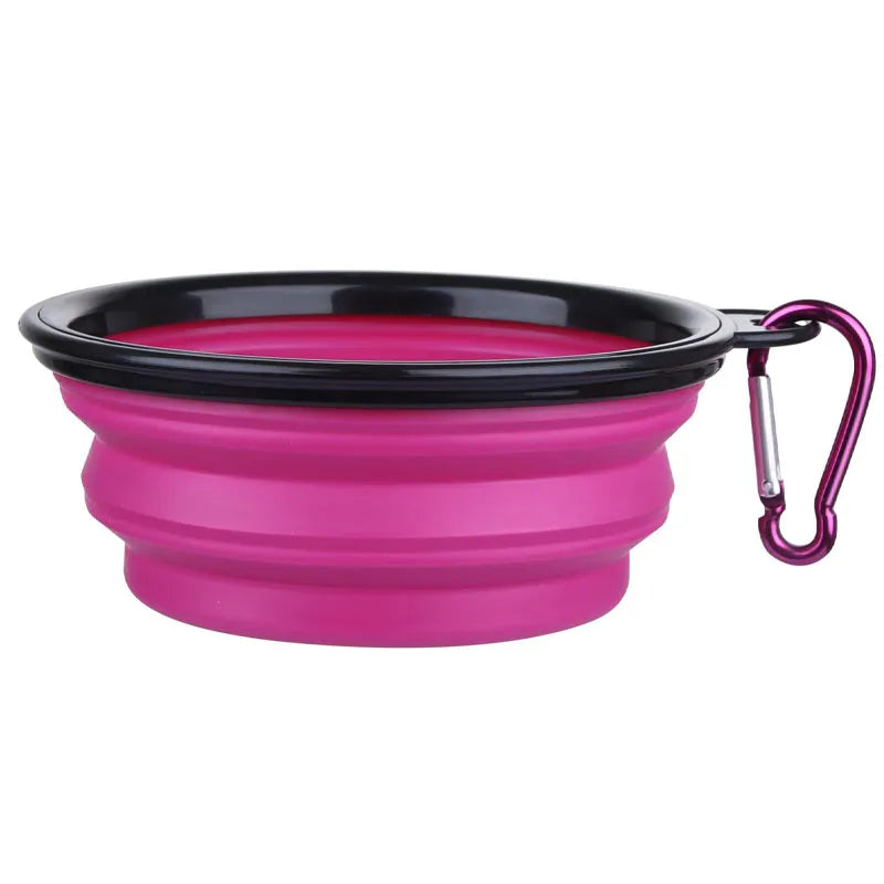 Pink and black collapsible dog bowl with a carabiner on a white background