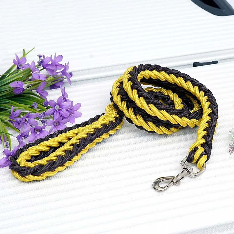 Black and yellow braided dog leash with a clip on a white surface with purple flowers.