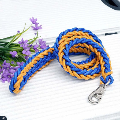 Blue and orange braided leash with a metal clip on a white surface with purple flowers.