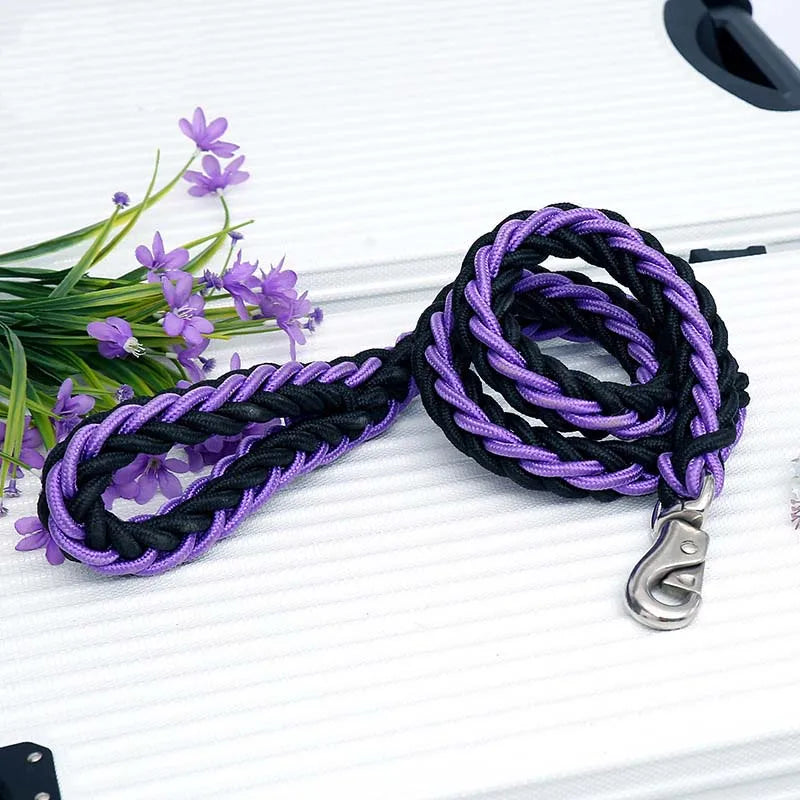 Black and purple braided leash with a metal clip on a white surface with purple flowers.