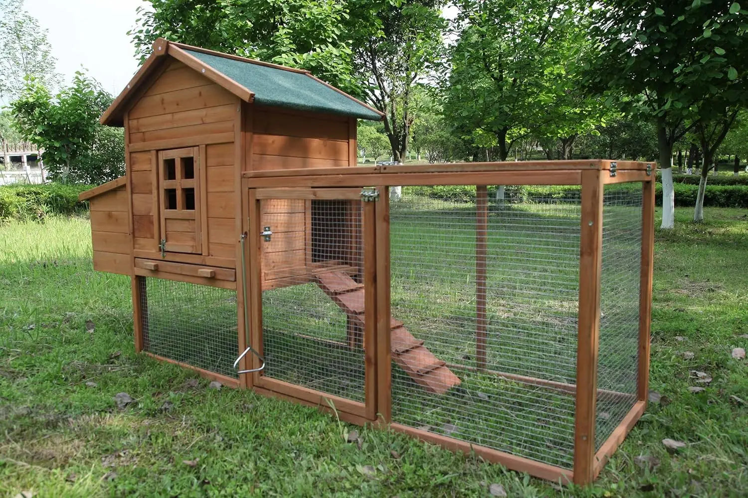 Wooden chicken coop with a green roof in a grassy outdoor setting