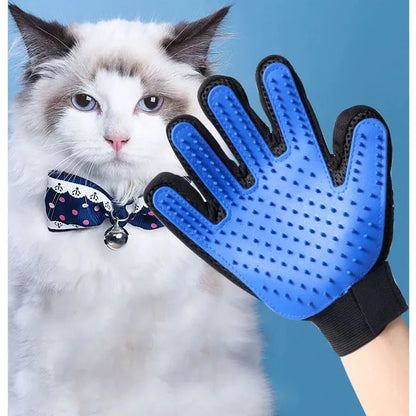 Blue pet grooming glove held by a hand next to a cat wearing a bow tie on a blue background