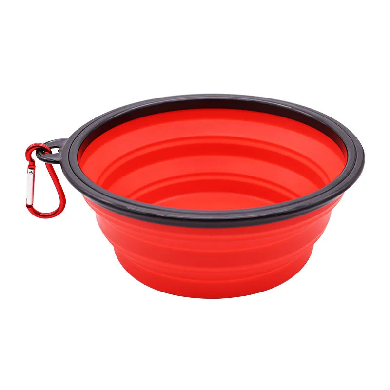 Red collapsible dog bowl with black rim and carabiner on a white background
