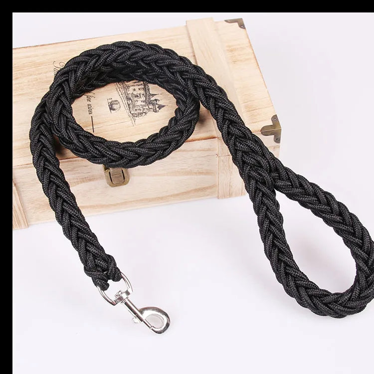 Black braided dog leash with metal clip on a wooden block