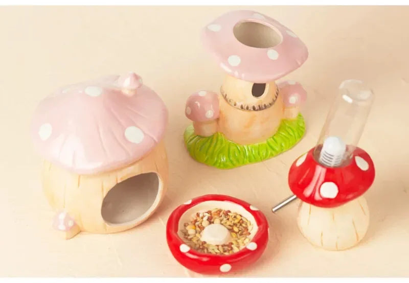 A set of ceramic mushroom-shaped pet toys and accessories, including a mushroom house, a mushroom-shaped dish, a small mushroom figurine, and a red-and-white mushroom feeder, arranged on a light beige background.