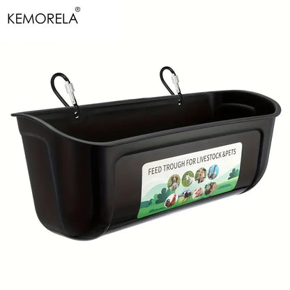 Black plastic hanging feed trough for livestock and pets, featuring two metal carabiner hooks on the sides and a front label that reads 'FEED TROUGH FOR LIVESTOCK & PETS'. The KEMORELA brand name is visible in the top left corner.