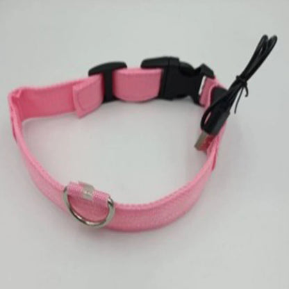 A pink adjustable fabric collar with black plastic buckles and a black wired remote control, displayed on a plain light gray background.