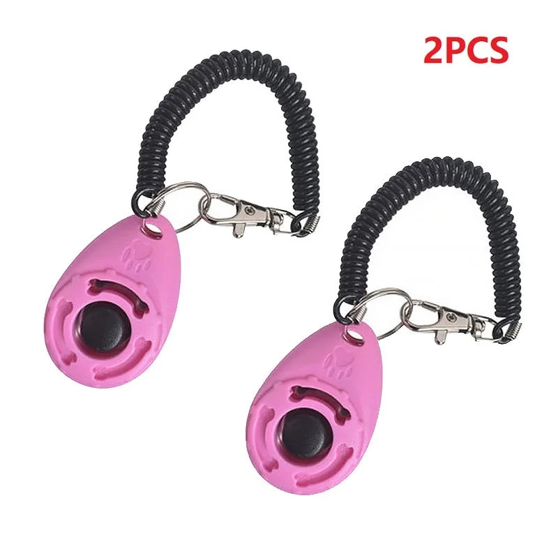 Two pink dog training clickers with black coiled leashes on a white background.