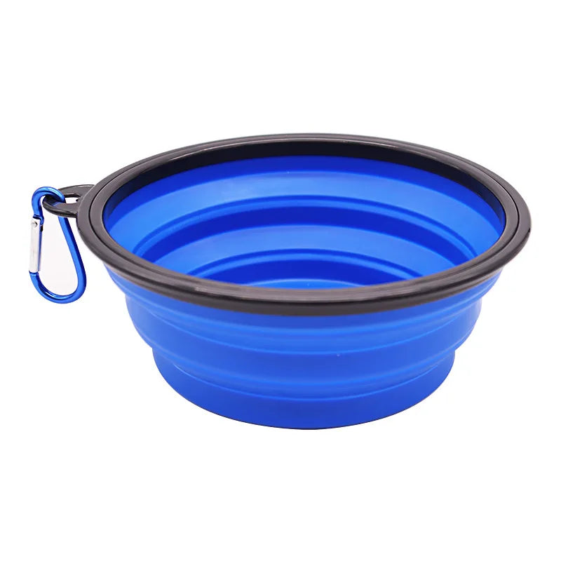 Blue collapsible dog bowl with black rim and blue carabiner on a white background