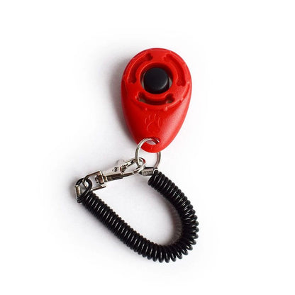 Red dog training clicker with black coiled leash on a white background