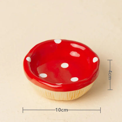 A small mushroom-shaped ceramic dish with a glossy red top and white polka dots, shown on a light beige background with dimension lines indicating 10 cm width and 4 cm height.