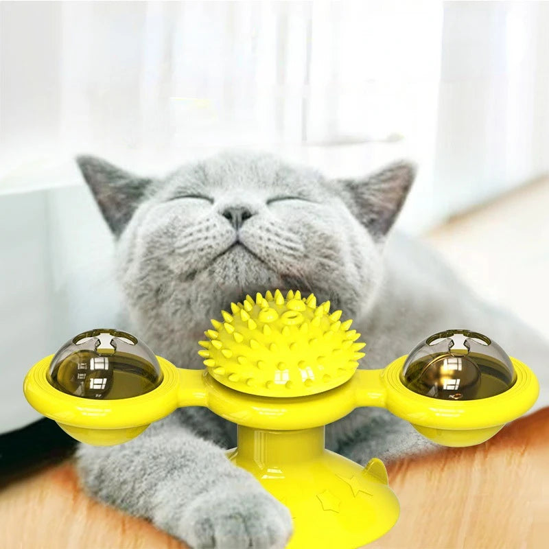 Cat playing with a yellow toy with two small cups and a central ball