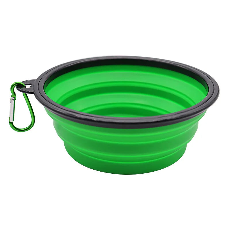Green collapsible dog bowl with black rim and carabiner on a white background