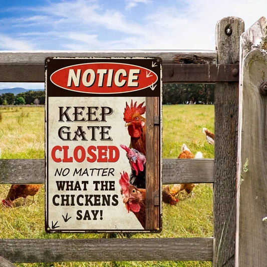 Metal sign on a wooden fence with chickens in the background