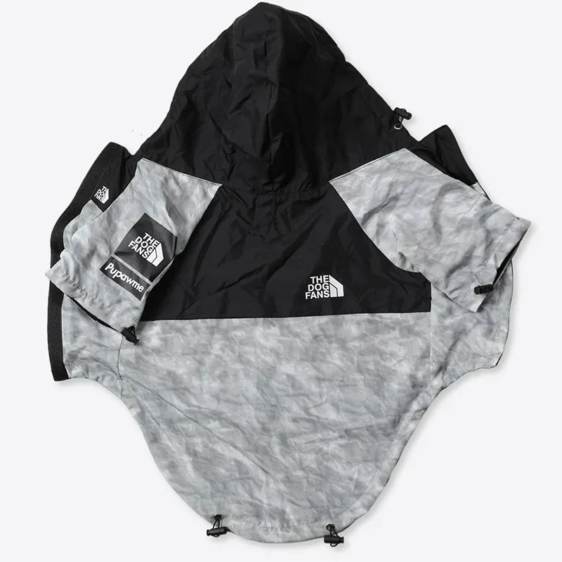 A hooded windbreaker jacket from The North Face, featuring a black upper section and a light gray camouflage patterned lower body and sleeves. The jacket is laid flat on a light gray background, showing the Hypotherm sleeve patch and the brand logo.