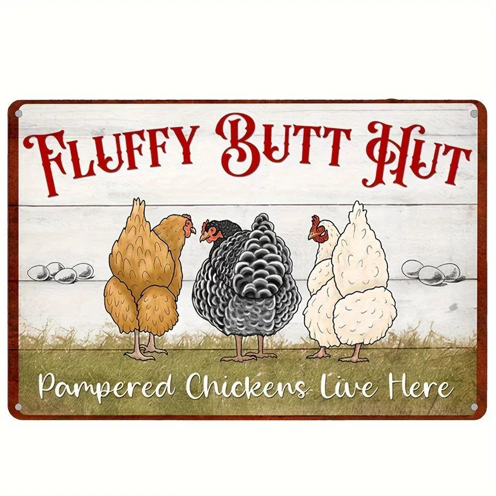 A rectangular decorative sign with a rustic white wood-plank background and red border. The sign features three illustrated chickens standing on grass, with the text 'FLUFFY BUTT HUT' in large red letters at the top and 'Pampered Chickens Live Here' in white script at the bottom.