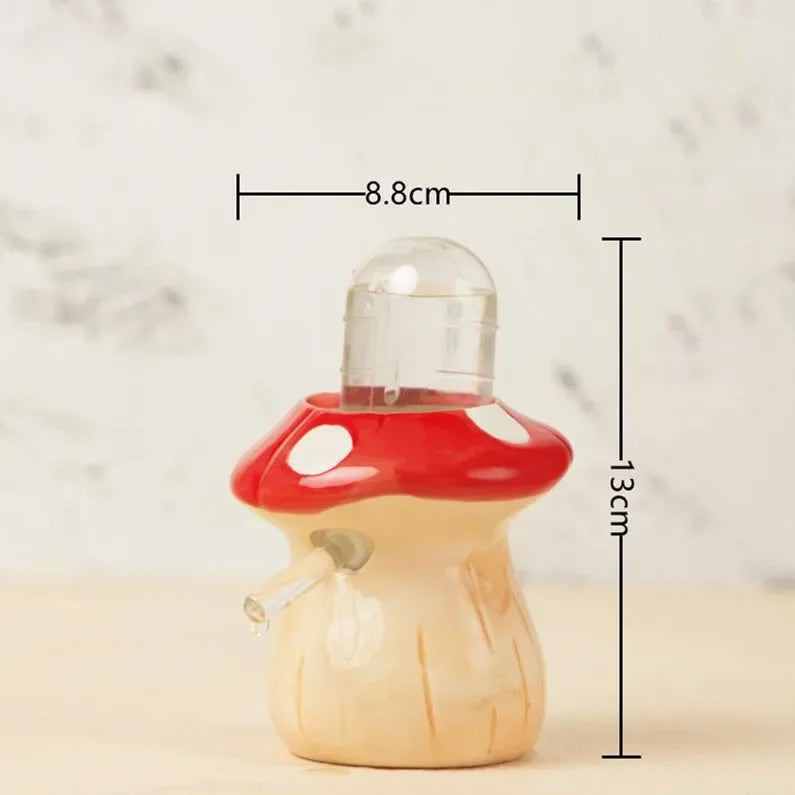 A small mushroom-shaped glass teapot with a red cap, white spots, and a beige stem, shown with dimension lines indicating a height of 13 cm and width of 8.8 cm.