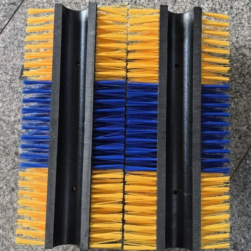 Cleaning brush with yellow and blue bristles on a gray surface
